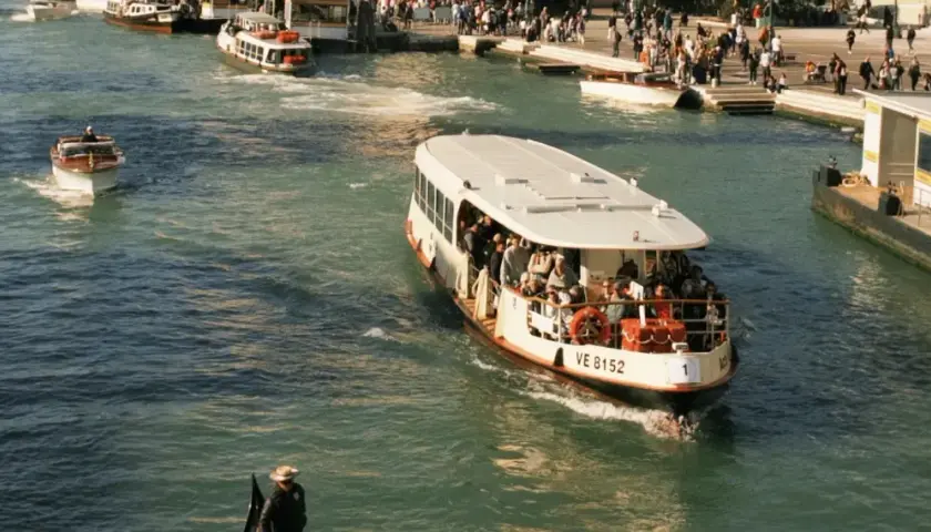 Ein belebter Vaporetto in Venedig transportiert Passagiere über das glitzernde Wasser.