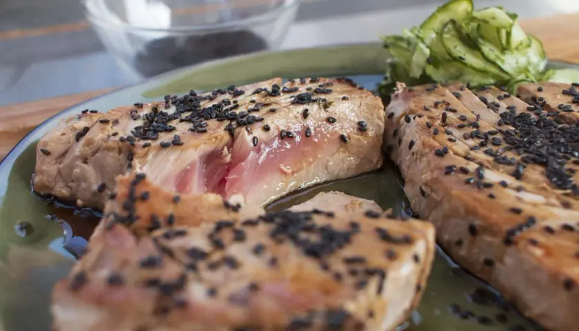 Perfekt gegrillter Thunfisch mit Sesam bestreut, serviert mit Gurkensalat. Ein Genuss für alle Sinne!