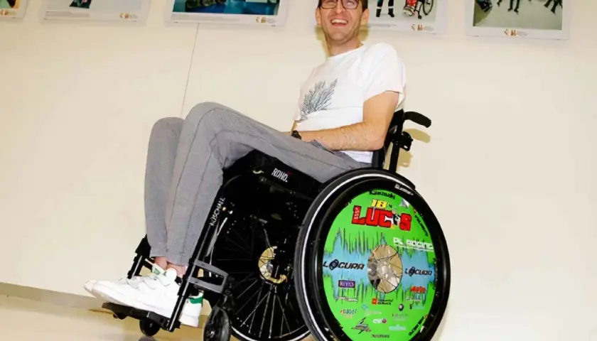 Lucas de Ulacia sonríe en su silla de ruedas, con la rueda decorada con "¡Lucas!".