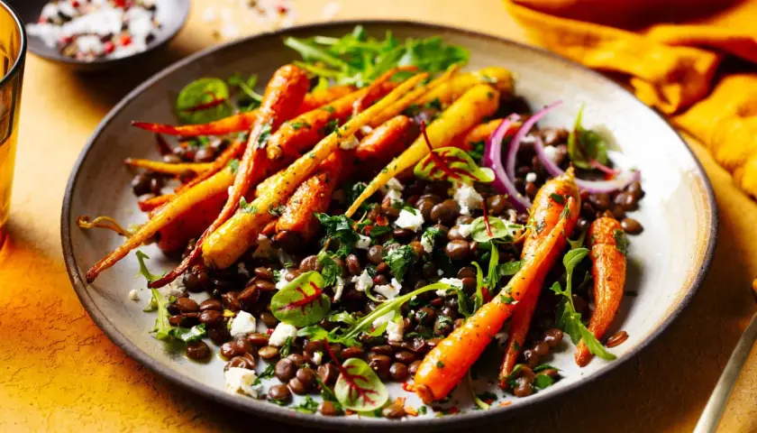Bunte Karotten mit Linsen, Feta und Kräutern – ein Fest für die Augen und ein Beweis für leckere vegetarische Gerichte.
