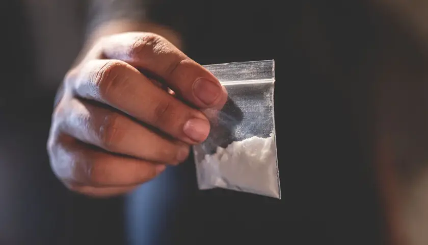 Dłoń trzyma woreczek z białym proszkiem. To może być związane z chemsex, czyli używaniem substancji psychoaktywnych w celu wzmocnienia doznań seksualnych.