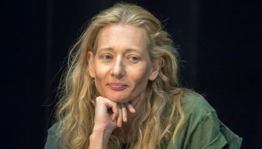 Magdalena Popławska, znana z wielu filmów i seriali, zamyślona, opiera podbródek na dłoni.