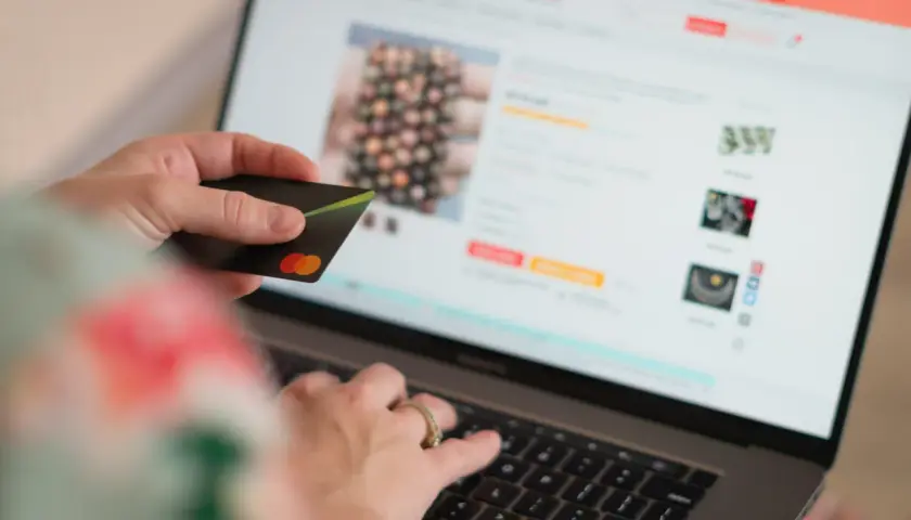 Persona compra en línea con tarjeta de crédito, dando su consentimiento explícito para la transacción.