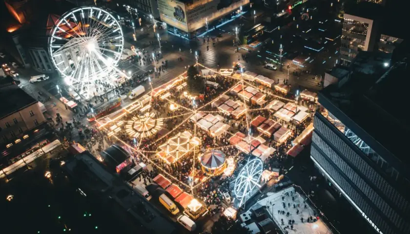 Nocny jarmark bożonarodzeniowy Katowice: rozświetlone stoiska, karuzela, diabelski młyn i lodowisko tworzą magiczną atmosferę.