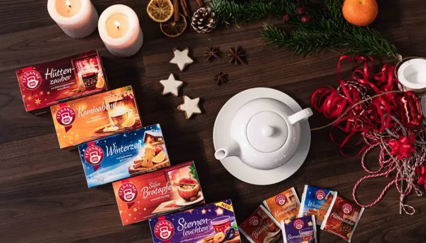 Gemütliche Teepackungen und Kerzen laden zum adventstee selber machen ein. Zimtsterne und Tannenzweige vollenden die winterliche Deko.