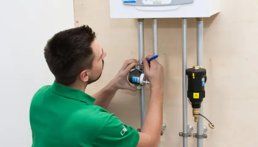 Instalator sprawdza, gdzie zamontować separator zanieczyszczeń przy kotle.