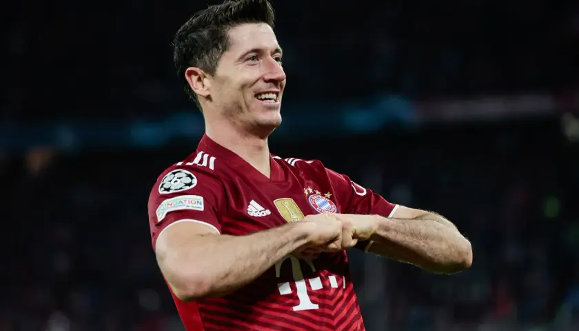 Robert Lewandowski, jeden z najlepszych króli strzelców Bundesligi, świętuje gola w czerwonej koszulce Bayernu Monachium.