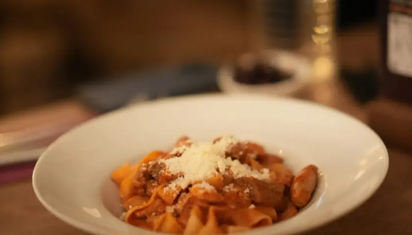 Pappardelle z sosem bolognese, posypane parmezanem. Pyszne danie, które może być inspiracją do przygotowania spaghetti bolognese przepis oryginalny.