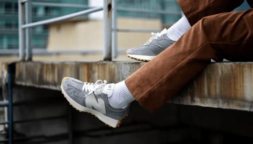 Szare New Balance na nogach w brązowych sztruksach. Zastanawiasz się, czy new balance można prać w pralce? Te wyglądają na czyste!
