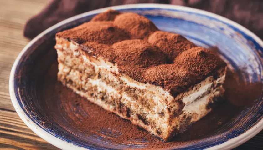 Pyszny kawałek tiramisu, co to znaczy? To włoski deser z kawą i kakao, który rozpływa się w ustach.