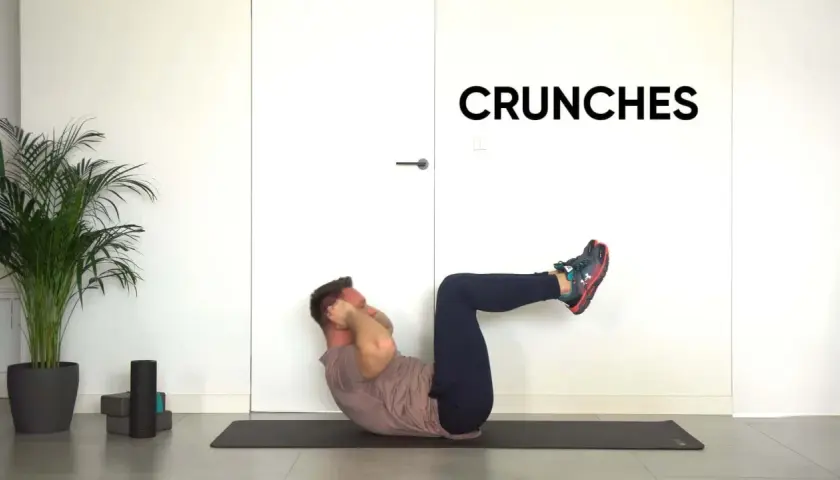 Mężczyzna wykonuje ćwiczenie ab crunch na macie.