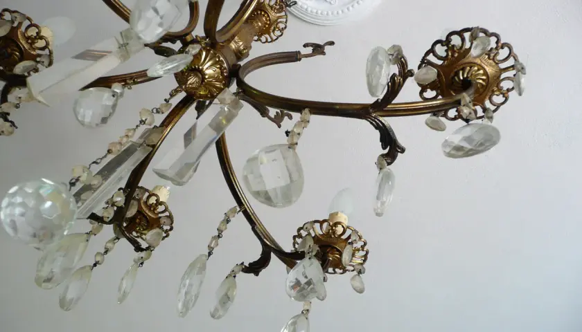 Dettagli di un lampadario a gocce in ottone con cristalli trasparenti. Un'idea su come rimodernare un lampadario a gocce con un tocco di eleganza.