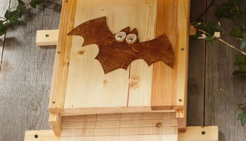 Ein selbstgebauter Fledermauskasten mit süßer Fledermaus-Deko. Perfekt für den Garten, um Fledermäuse anzulocken.