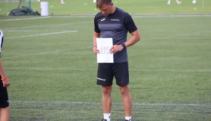 Trener analizuje schemat ruchów na boisku, przygotowując test matthiasa.