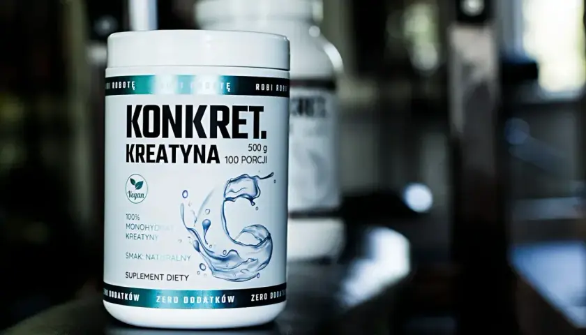 Biały słoik z napisem "KONKRET. KREATYNA" i grafiką wody. To suplement diety, jaka kreatyna dla Ciebie?