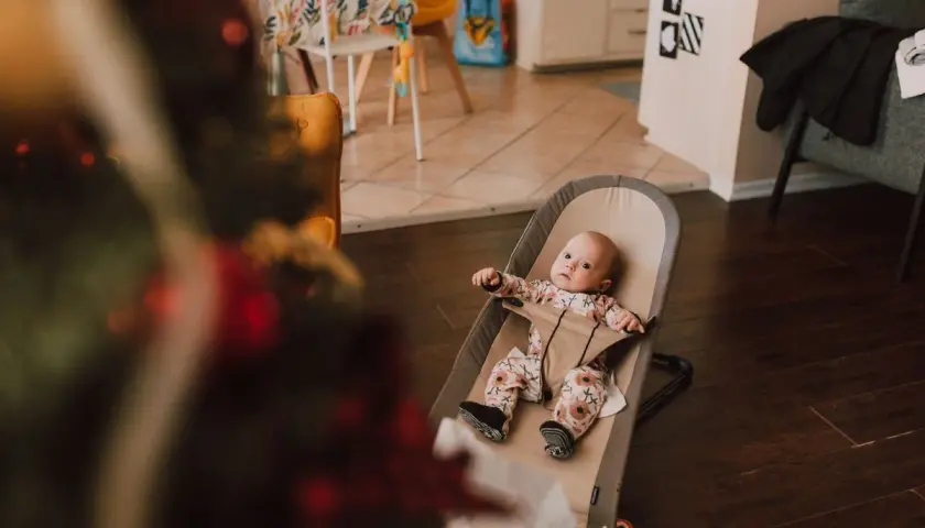 Söt bebis i en beemoo babysitter, redo för lek eller en tupplur.