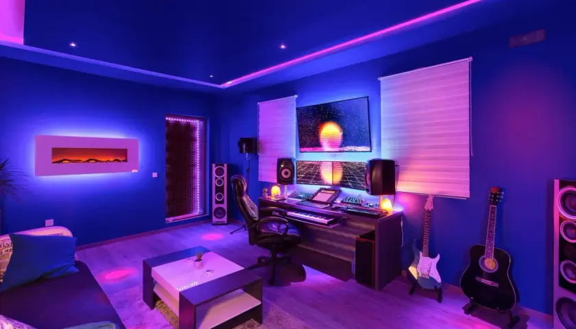 Estudio de música con **plafón led colores** vibrantes, guitarras, equipo de sonido y pantallas.