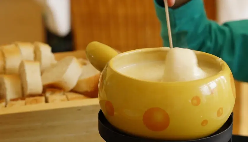 Un délicieux fondue suisse fromage crémeux, prêt à être dégusté avec du pain croustillant.