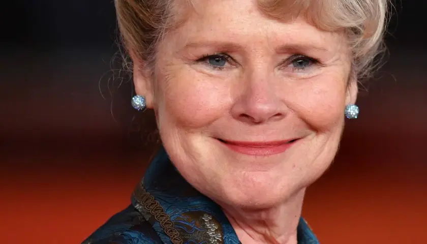 Uśmiechnięta Imelda Staunton, znana z roli Dolores Umbridge w Harry Potter, w błyszczących kolczykach.