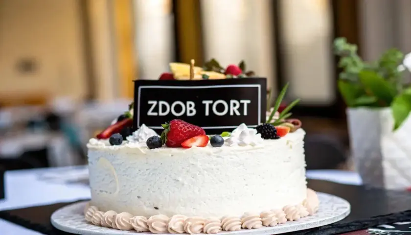 Elegancki tort dla 14 latki, ozdobiony świeżymi owocami i napisem "Zdob Tort". Idealny na wyjątkową okazję.