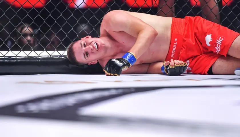 Zawodniczka MMA leży na macie, z grymasem na twarzy. Czy ma tyle lat, ile ostry od czajnika?