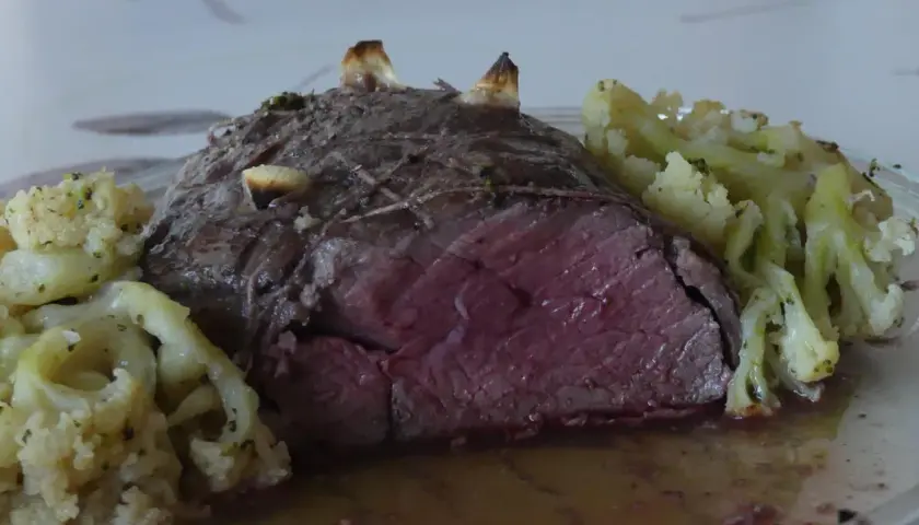 Un rôti de bœuf des Highlands, saignant et tendre, servi avec du chou-fleur rôti aux herbes.
