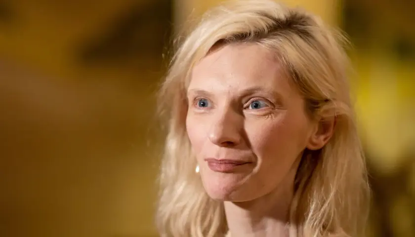 Agata Buzek zamyślona, być może wspominająca swoje dzieci. Jej spojrzenie kieruje się w bok, a na twarzy maluje się delikatny uśmiech.