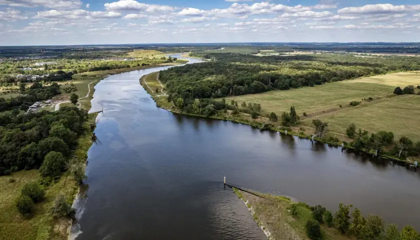 Malowniczy widok na rzekę i tereny zielone, idealne na spacer z psem. Psie pole Wrocław zaprasza!