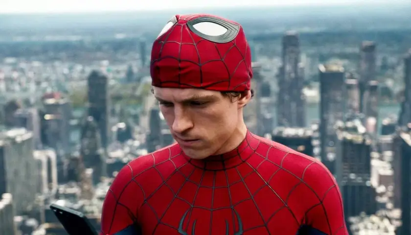 Spider-Man, con il suo costume rosso e blu, guarda un tablet con uno sfondo di grattacieli. Una recensione di Spider-Man che cattura l'essenza del personaggio.