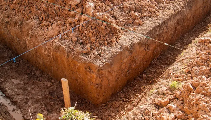 Wykonano wykopy pod fundamenty. Widać głębokie okopy ziemi, wyznaczone sznurkami.