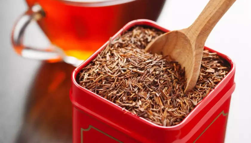 Czerwona herbata rooibos w metalowym pudełku, gotowa do zaparzenia. Bez kofeiny, idealna na relaks.