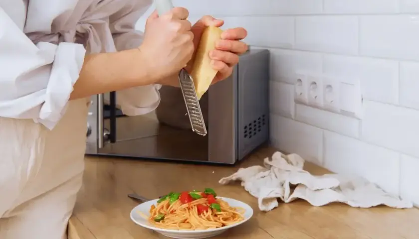 Szybki obiad? Zobacz, jak ugotować makaron w mikrofali i posypać go parmezanem.