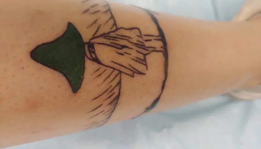 Nowy tatuaż muminki na nodze. Zielony kapelusz i zarys postaci.