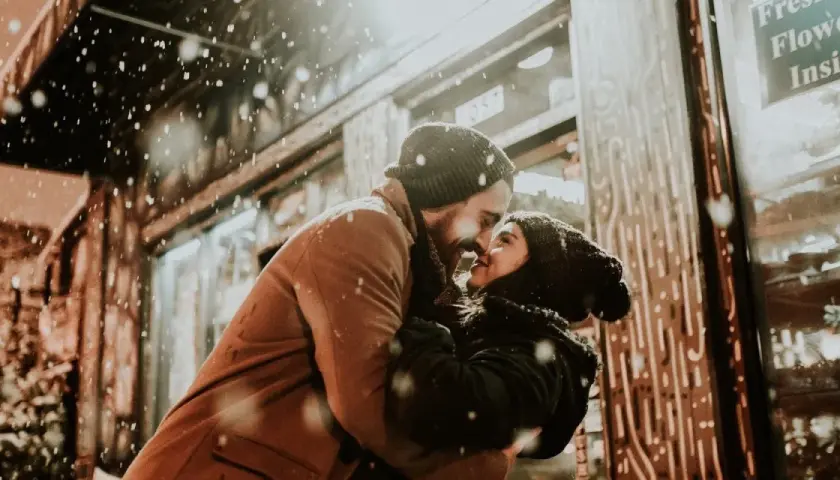 Coppia che si abbraccia sotto la neve, con lui che la guarda intensamente. Se lui non ti desidera, non ti ama.