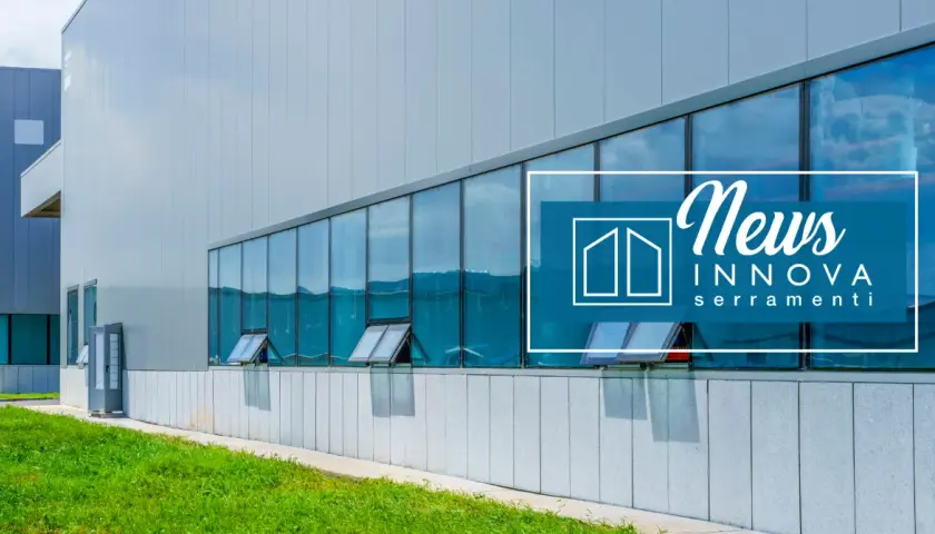 Edificio moderno con ampie vetrate riflettenti e infissi industriali. Logo "News Innova serramenti" sovrapposto.