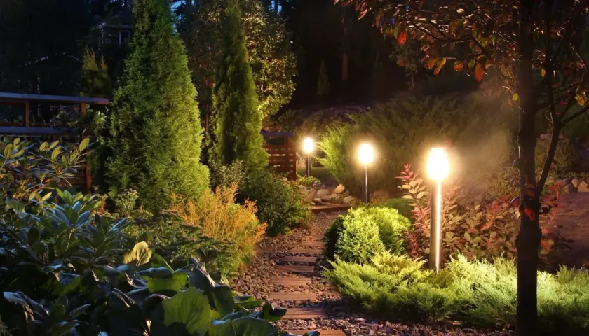 Pięknie oświetlony ogród nocą. Lampki solarne, które same się ładują, tworzą magiczną atmosferę.