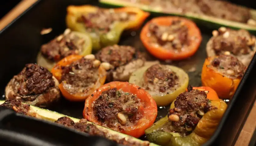 Délicieux légumes farcis, tomates, poivrons et courgettes, garnis d'une savoureuse farce à la viande et aux pignons.