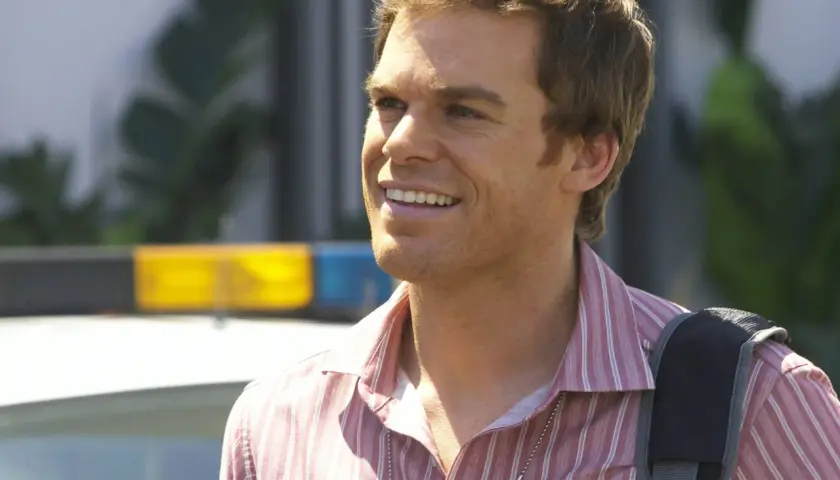 Michael C. Hall som Dexter Morgan, med en polisbil i bakgrunden.