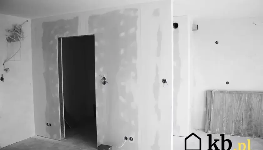 Niedokończone ściany z gładzi, widoczne otwory na instalacje i drzwi.