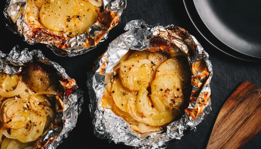 Pommes de terre en papillote, idéales pour un barbecue au gaz. Savoureuses et tendres, elles sont prêtes à être dégustées.
