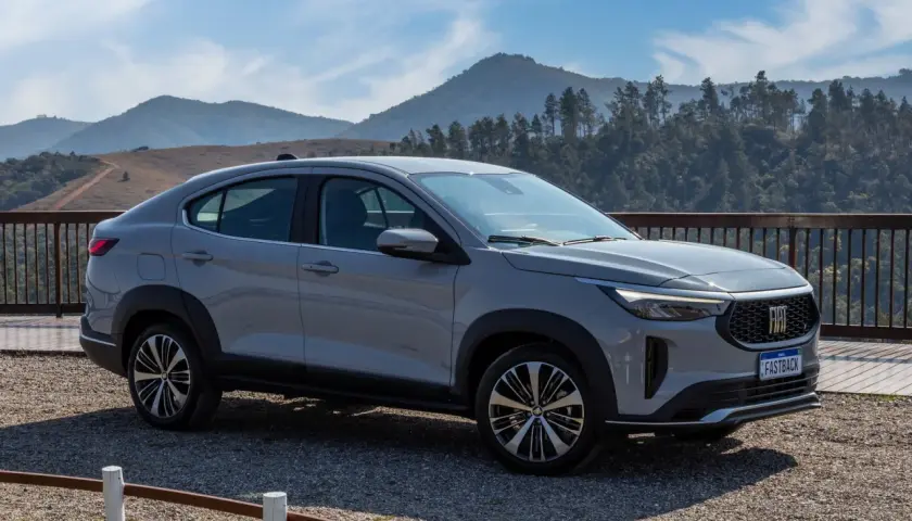 Fiat Fastback 2026 grigio metallizzato, un SUV coupé con un design audace, parcheggiato su un bel belvedere montano.