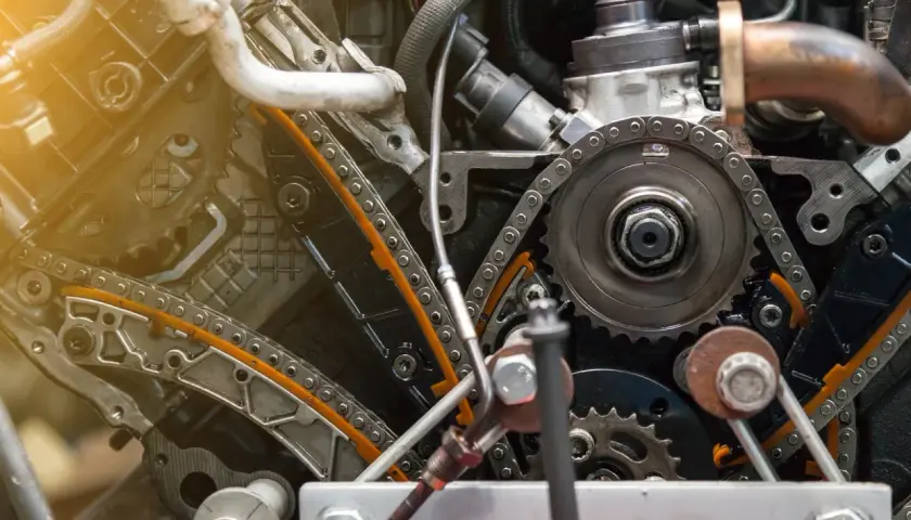 Widok mechanizmu rozrządu w silniku diesla. Zastanawiasz się, jak często wymieniać rozrząd w dieslu? Ten obraz pokazuje skomplikowany układ łańcuchów i kół zębatych.