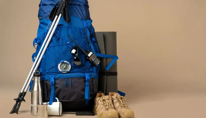 Jaki plecak w góry na 3 dni? Niebieski plecak, kijki trekkingowe, karimata, buty, kompas, termos i krótkofalówka.