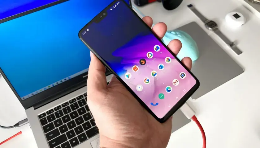 Podłączanie telefonu z Androidem do laptopa, aby łatwo przesłać zdjęcia. Widoczny kabel USB.