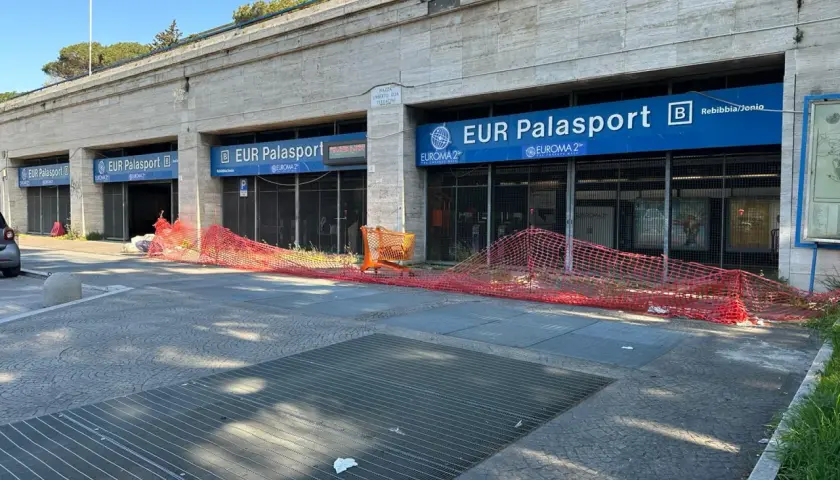 Roma, parcheggio gratuito metro EUR Palasport. Recinzione arancione davanti all'ingresso della metro.
