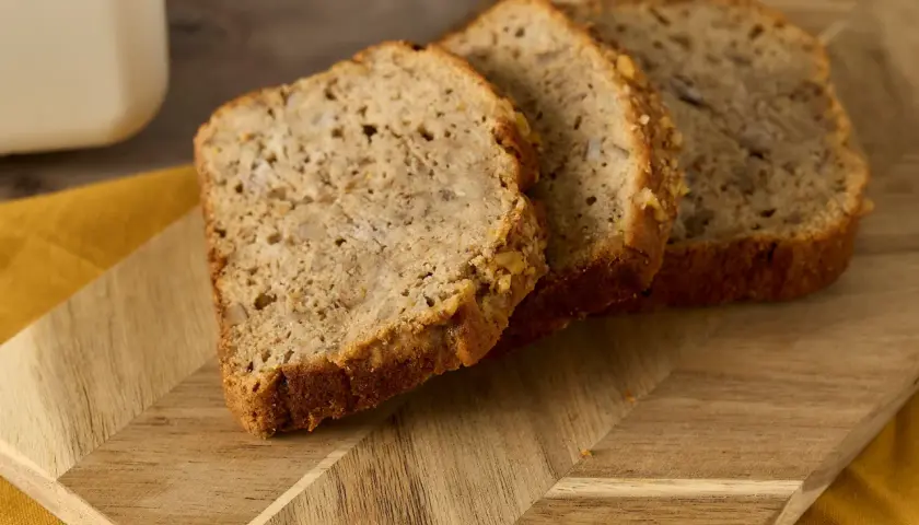 Tre skivor bananbröd på en träskärbräda. Perfekt för att se om man kan frysa om bröd och njuta av senare.