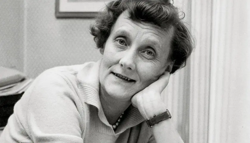 En ung Astrid Lindgren lutar sig mot sin hand, med ett drömmande uttryck.