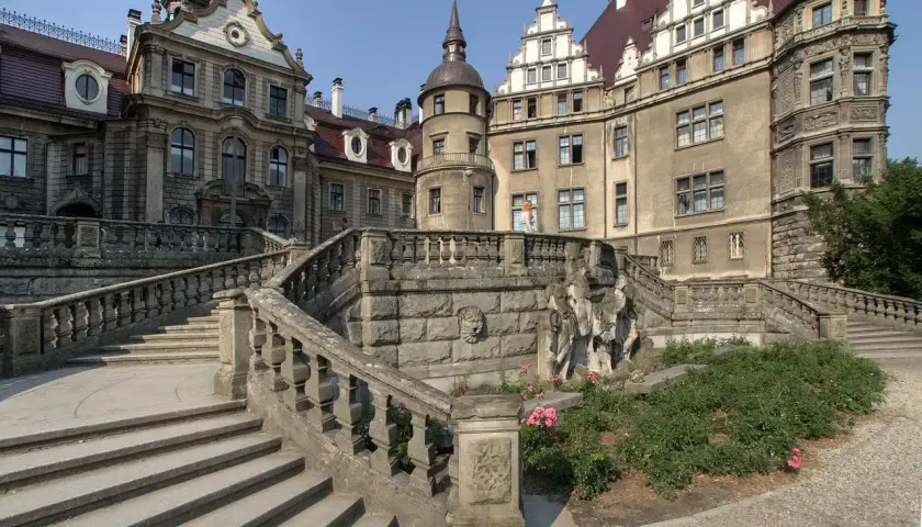 Kamienny zamek z wieżą i schodami. Warto zobaczyć, co to za moszna budowla!