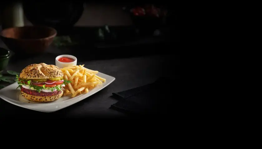Pyszny, wegetariański konkret burger z Orlenu, podany z chrupiącymi frytkami i ketchupem. Idealny na szybki posiłek.