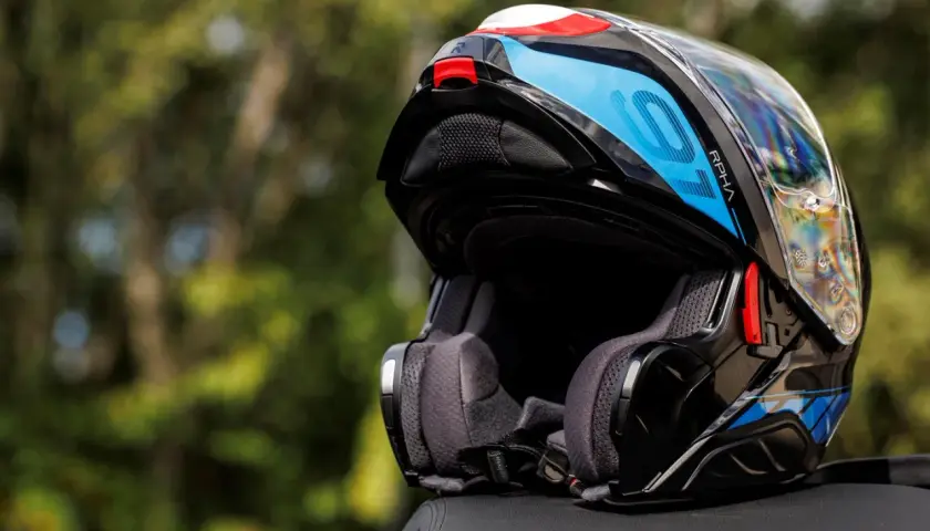 Kask motocyklowy RPHA 91 w kolorze czarnym z niebieskimi i białymi akcentami, gotowy na kolejną podróż.